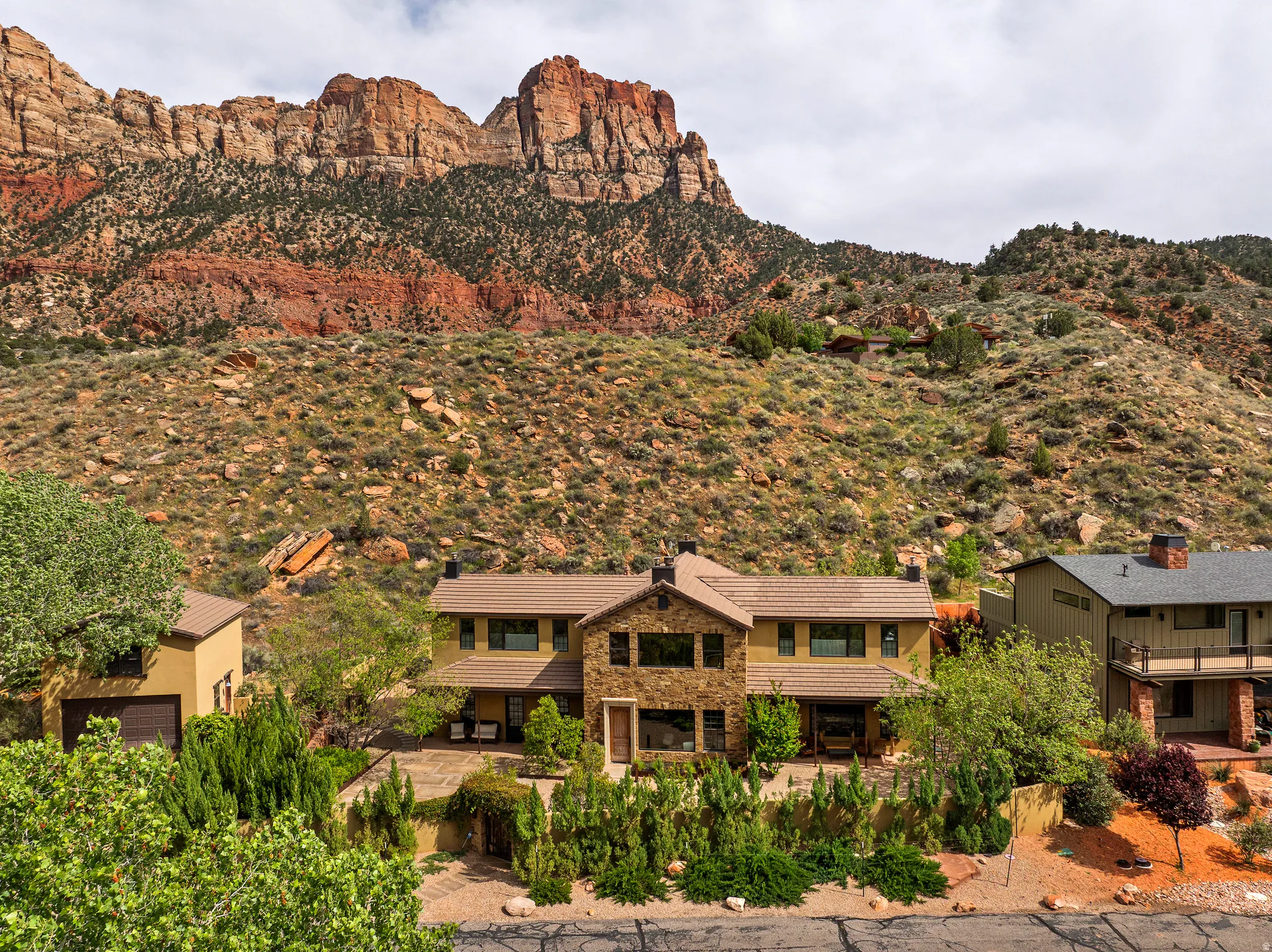Multi-level residence featuring a stone and stucco exterior
