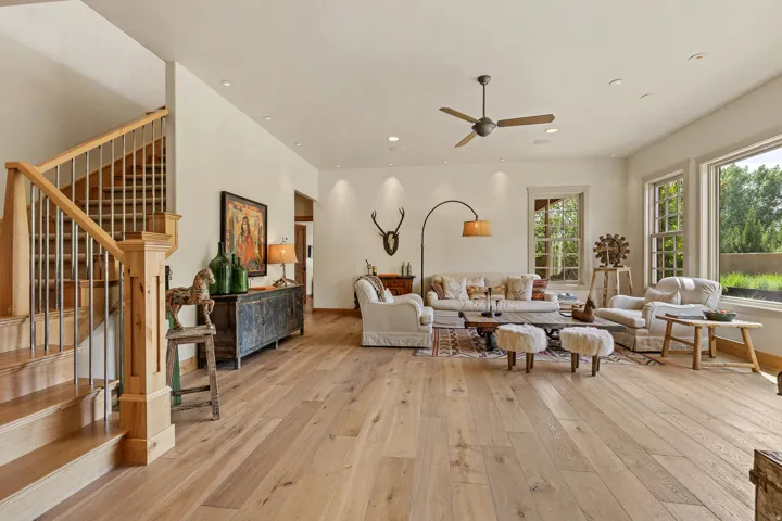 Spacious living area featuring light wood-finish flooring, a ceiling fan, and recessed lighting