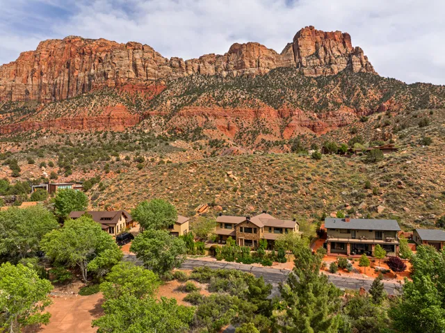 Red rock mountain backdrop with multiple residential properties nestled into the hillside