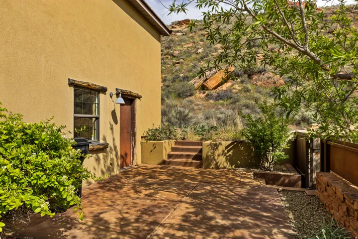 Exterior with stucco siding, a wood entry door, and a single window featuring wood trim