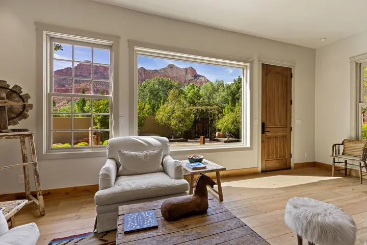 Expansive picture window framing mountain scenery and mature landscaping