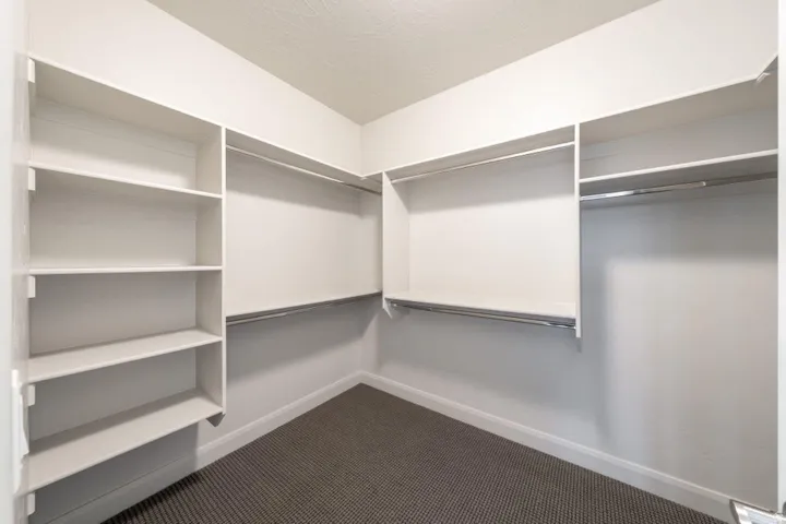Custom closet system featuring white shelving and chrome hanging rods