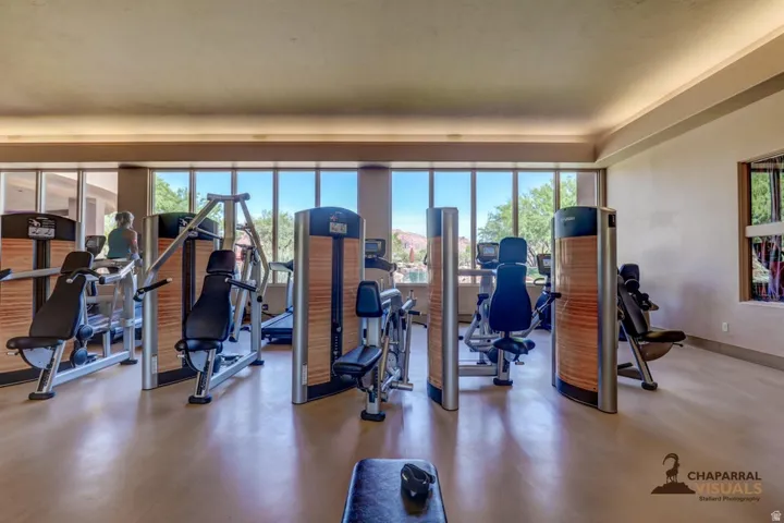 Fitness center with expansive window-lined walls, smooth flooring, and ceiling soffit lighting