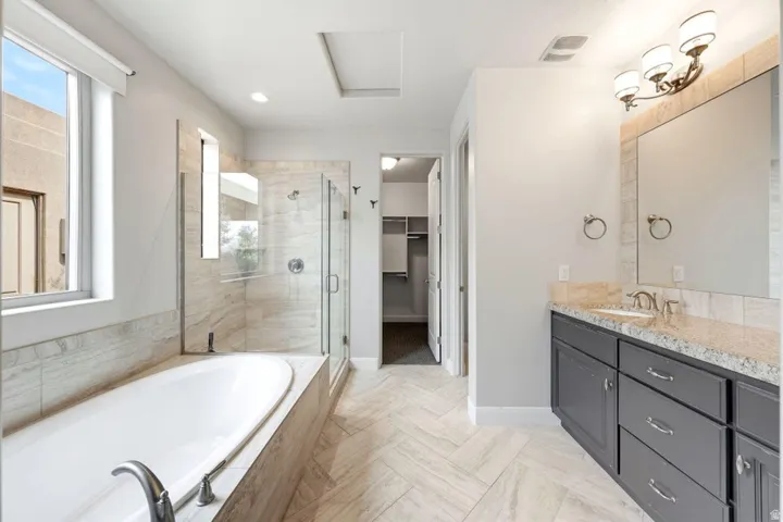 Dual vanity with a stone-finish countertop, undermount sink, and brushed nickel fixtures