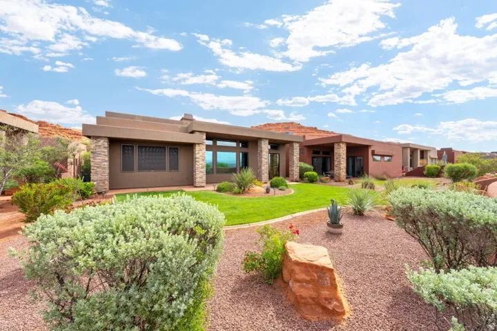 Contemporary desert architecture featuring a flat roofline, stone veneer accents, and stucco exterior