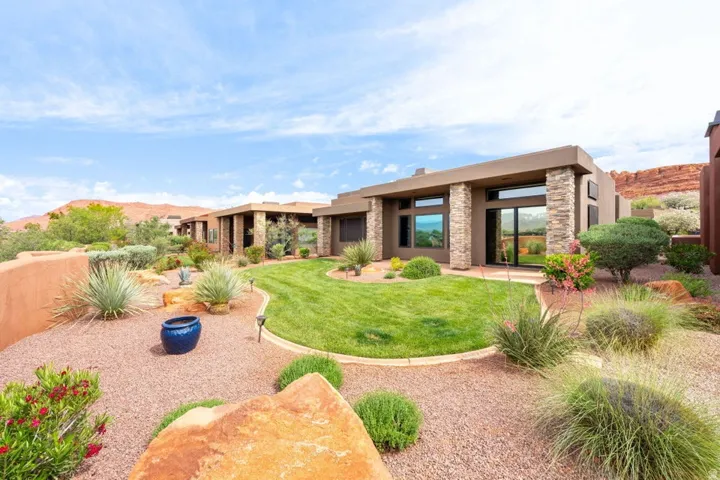 Contemporary desert-style residence with stucco exterior and stone-clad pillars