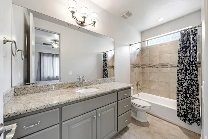 Vanity with a light-toned countertop, undermount sink, and brushed nickel faucet