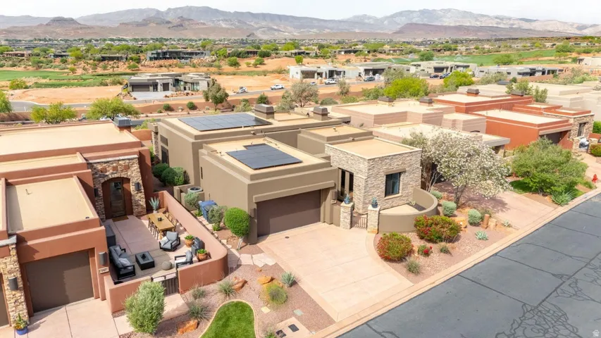 Southwestern contemporary architecture featuring solar panels, a stone-clad facade, and a private courtyard