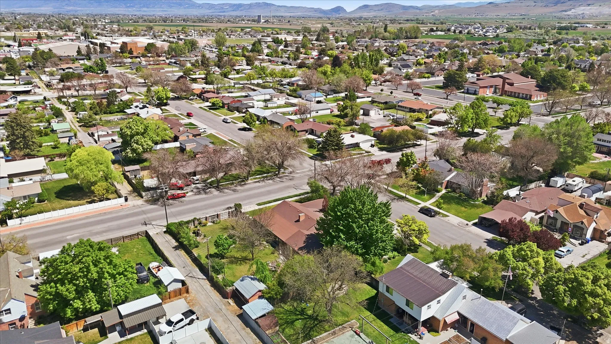 Suburban neighborhood featuring varied residential architecture, mature landscaping, and paved roadways