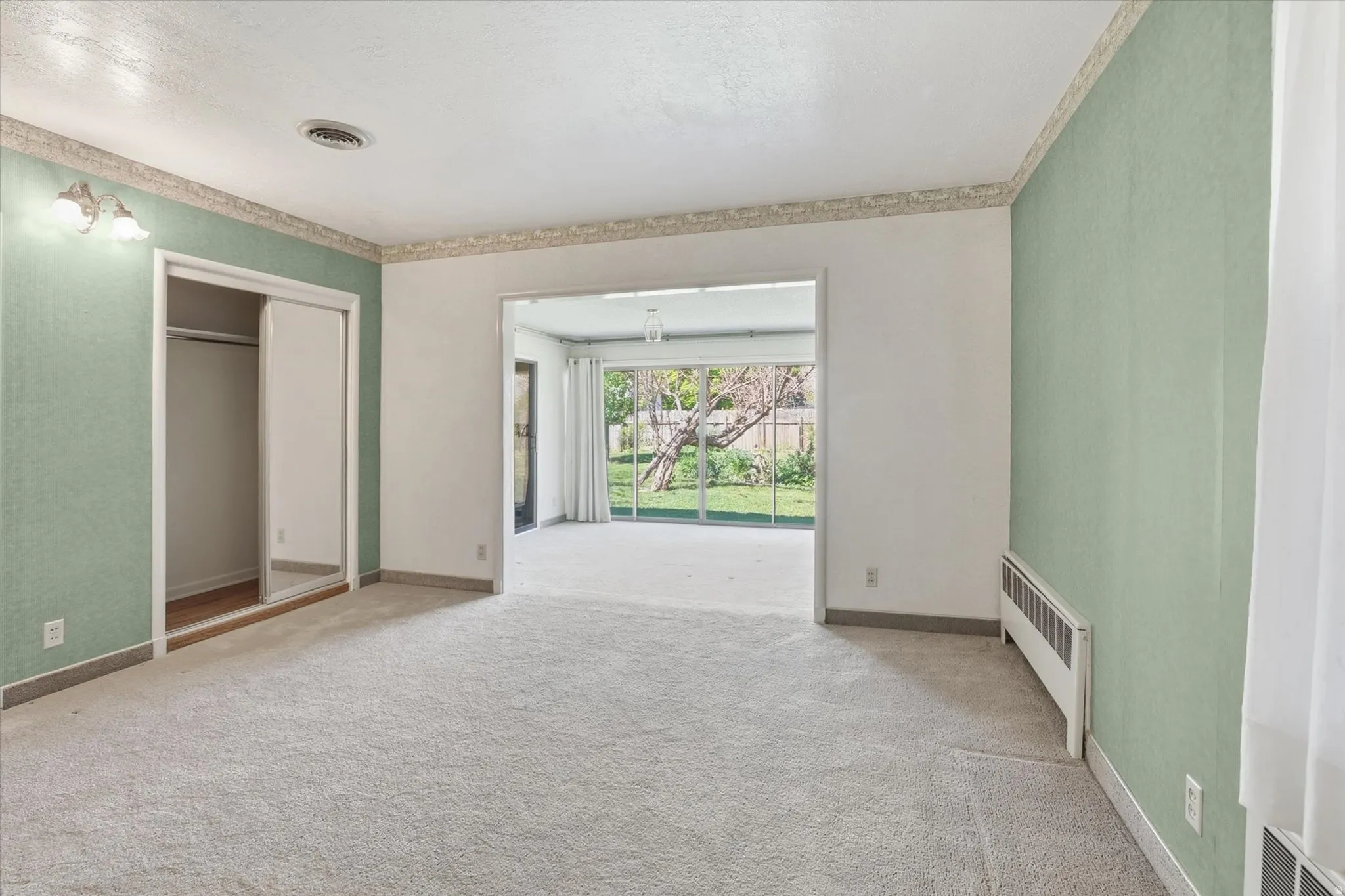 Carpeted interior space with mint green accent walls and white trim