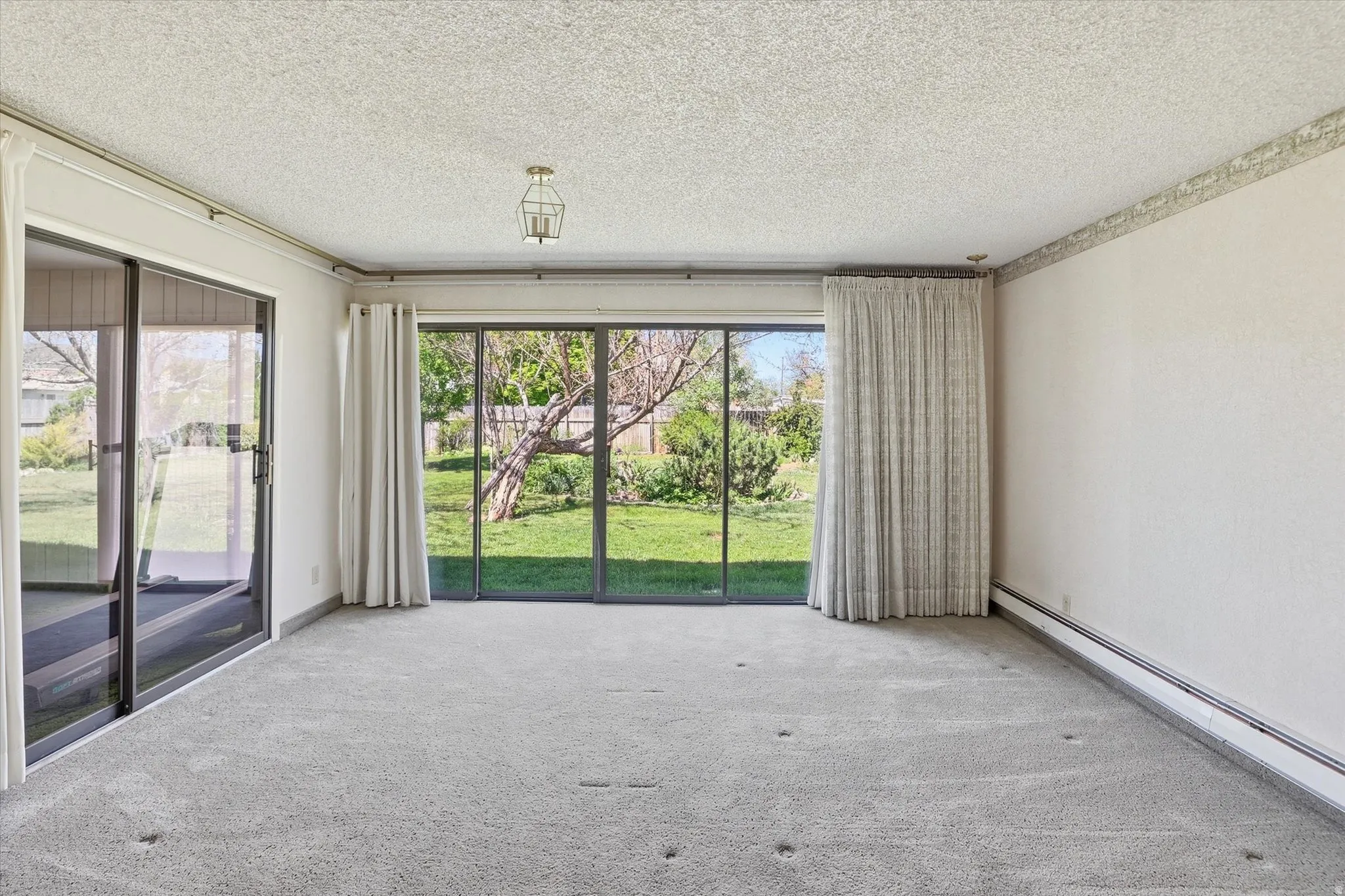 Light gray carpeting with baseboard heating