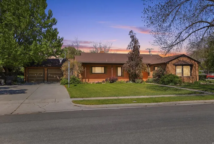 Ranch-style residence featuring a stucco exterior and a dark shingle roof