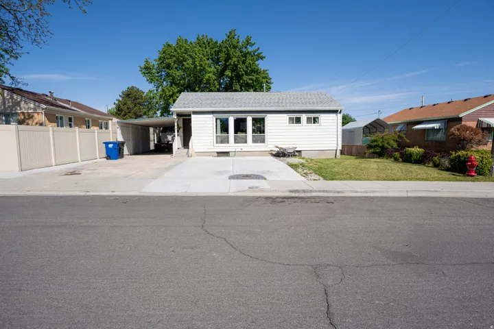 White-sided residence featuring a gray shingle roof, front-facing windows, and a concrete driveway