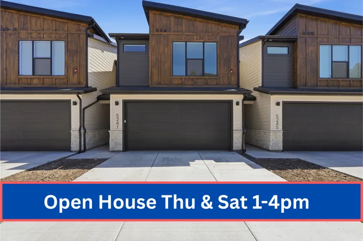 Contemporary multi-story exterior featuring a dramatic sloped roofline, wood-finish siding, dark gray horizontal paneling, and stone veneer accents