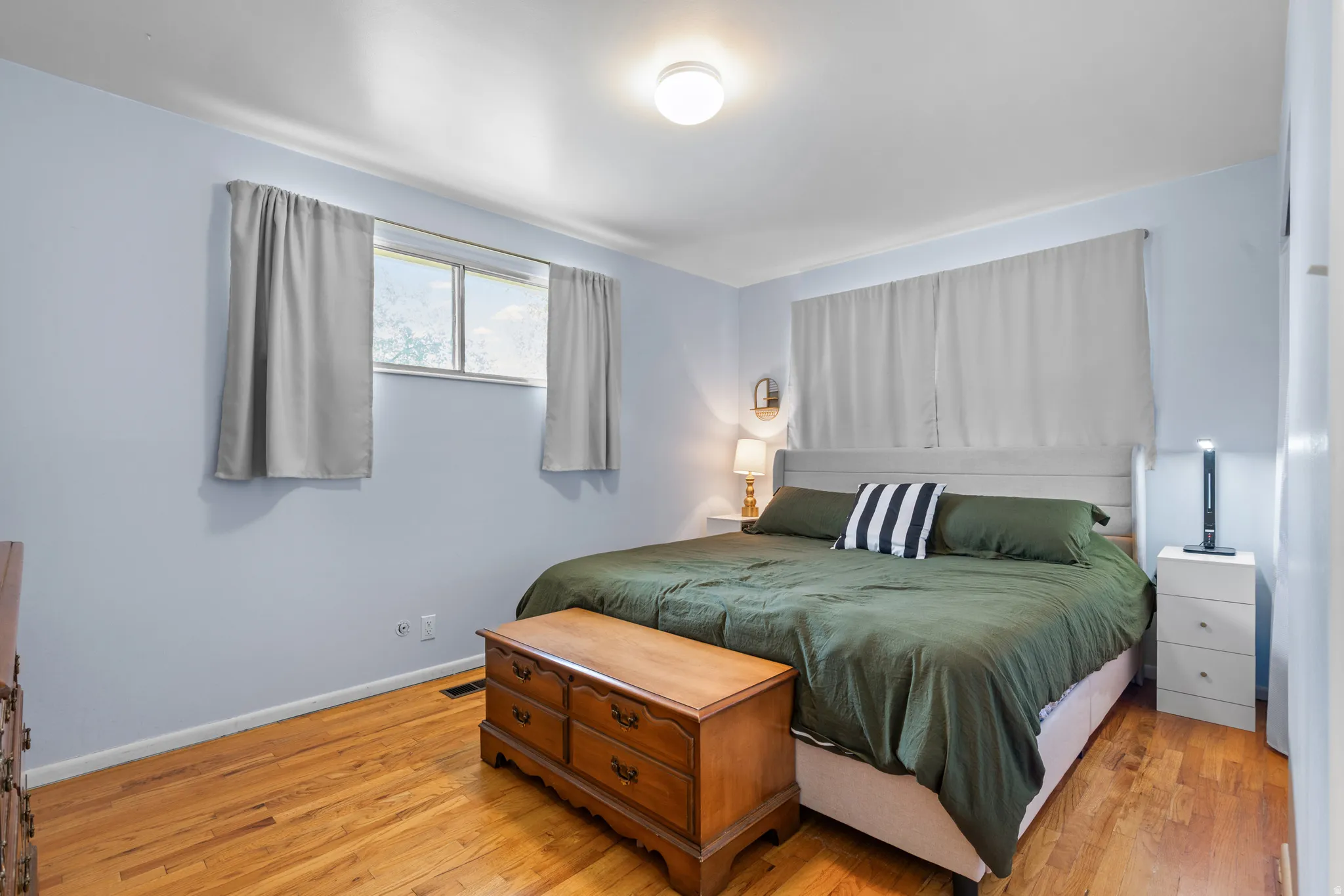 Bedroom featuring wood-finish flooring and light blue walls