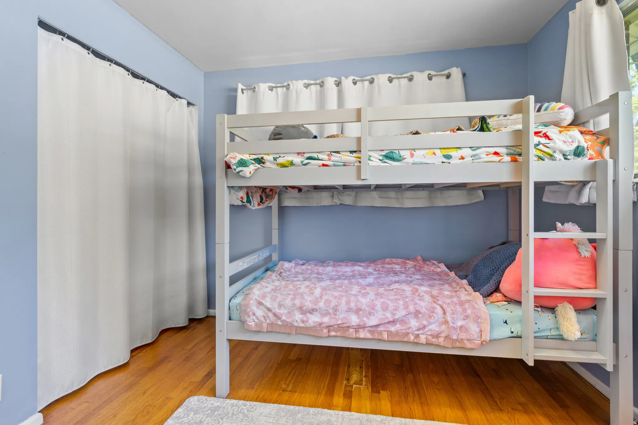 Room featuring light blue walls and wood-finish flooring