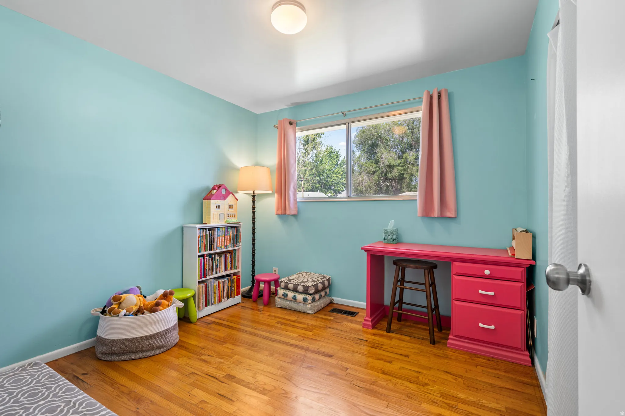 Room featuring wood-finish flooring, a double window, and recessed lighting