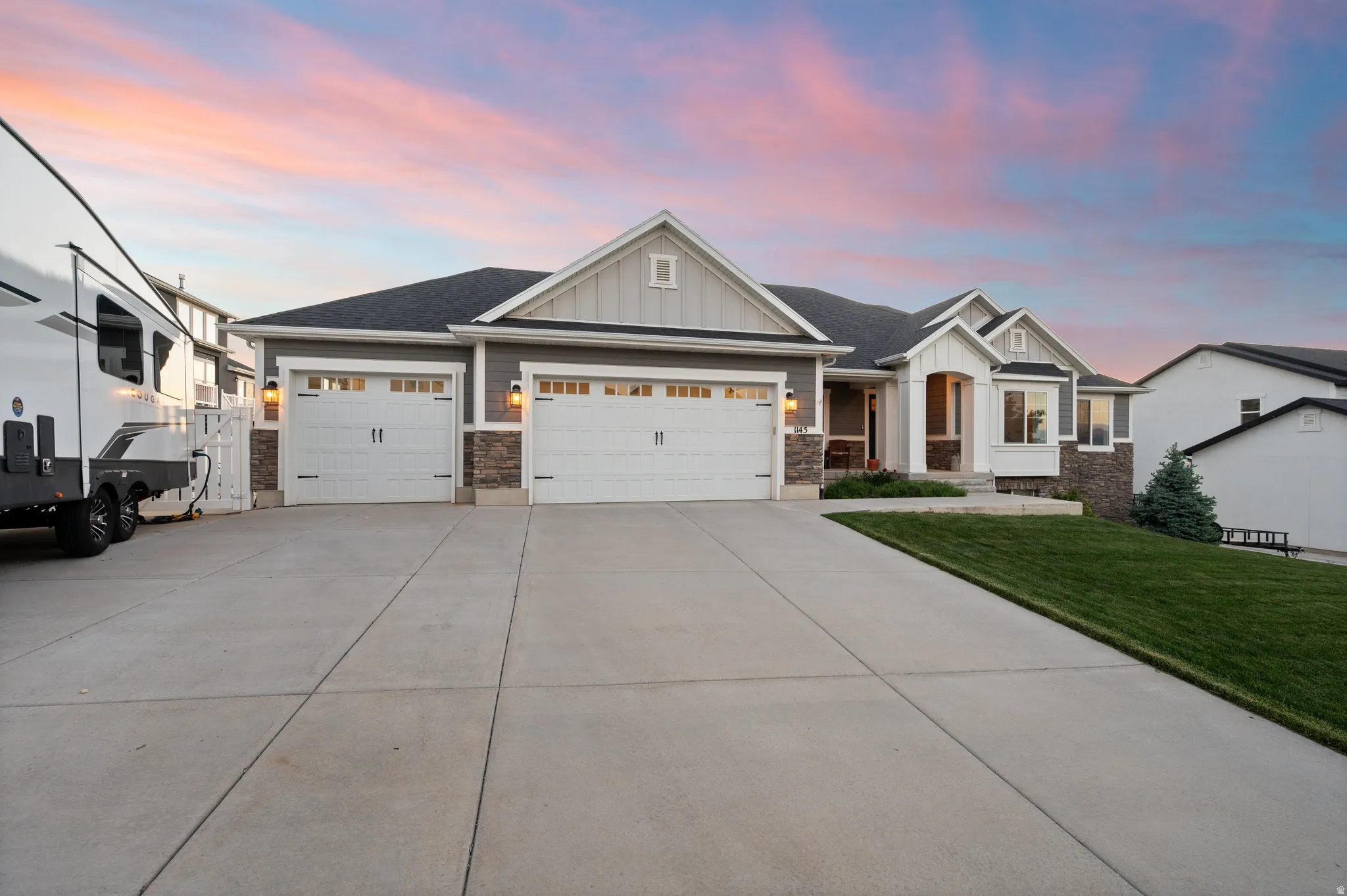 Contemporary single-story residence with a multi-car driveway, attached garage, and stone accents