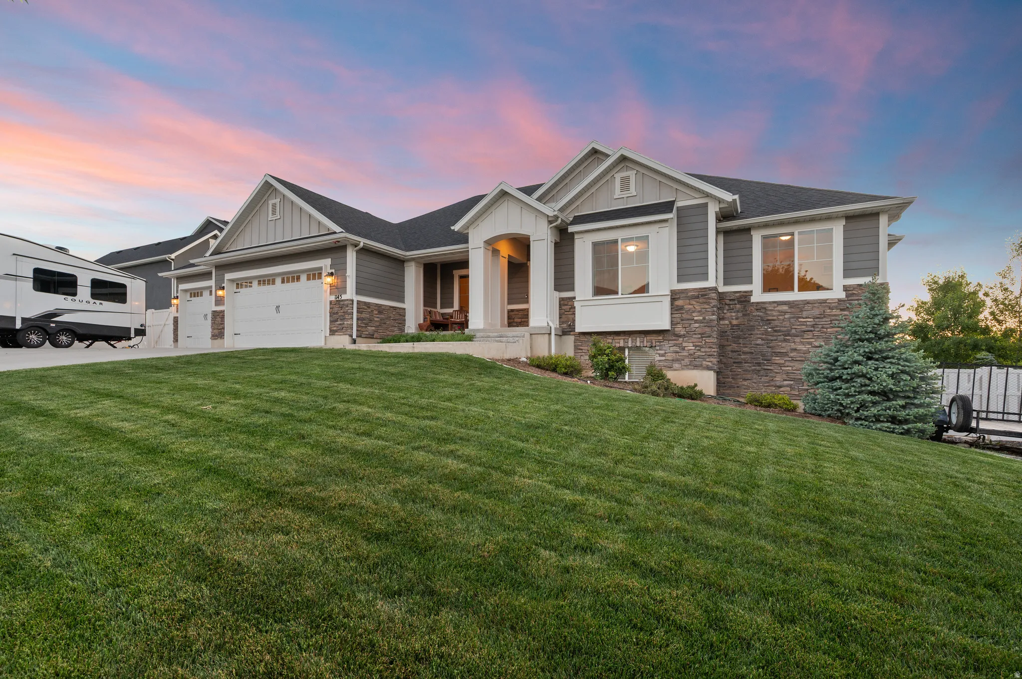 Split-level residence featuring a stone and siding facade