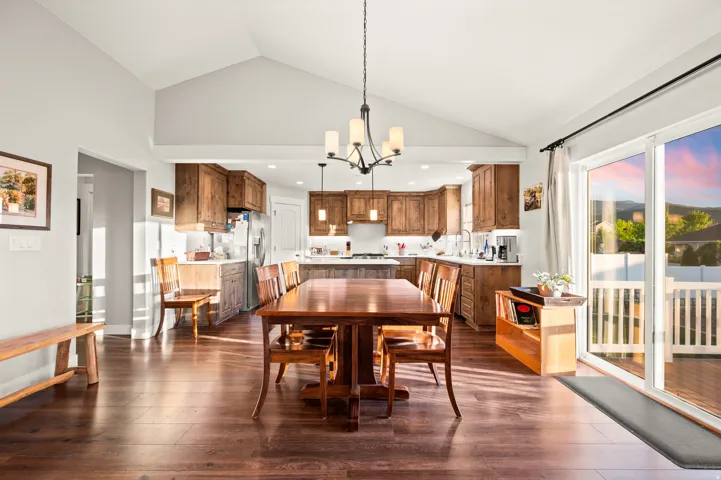 Open-concept living area featuring a vaulted ceiling and wood-finish flooring