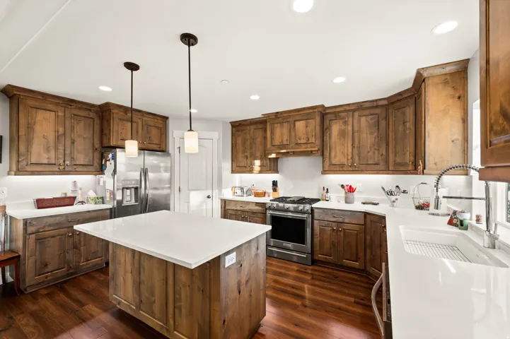 Kitchen featuring wood-finish flooring, custom wood cabinetry, and white countertops