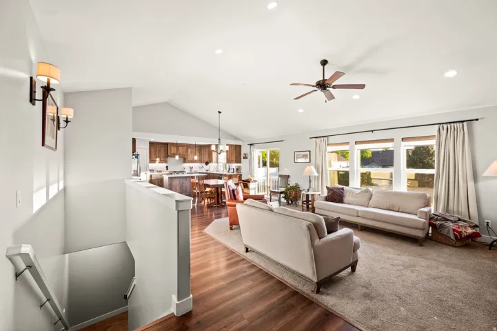 Spacious living area featuring vaulted ceilings, recessed lighting, and a ceiling fan