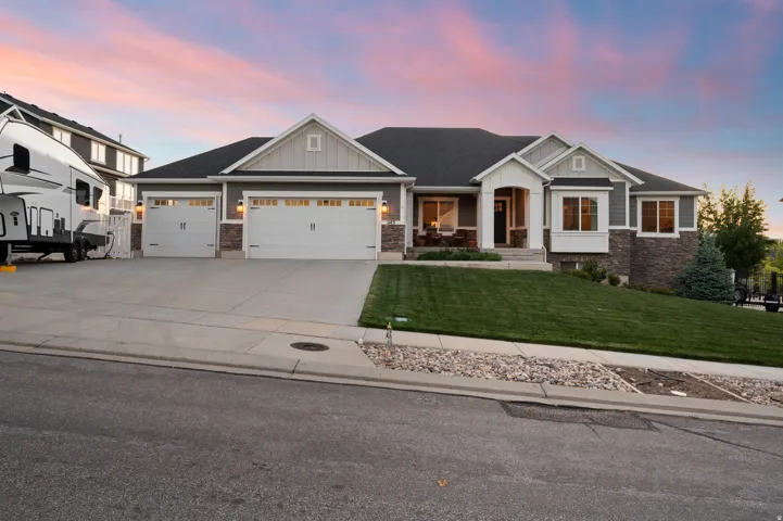 Contemporary ranch-style residence featuring a gray exterior with stone accents and white trim