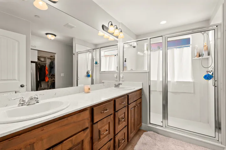 Master bathroom featuring a dual vanity with wood-finish cabinetry and light-toned countertops