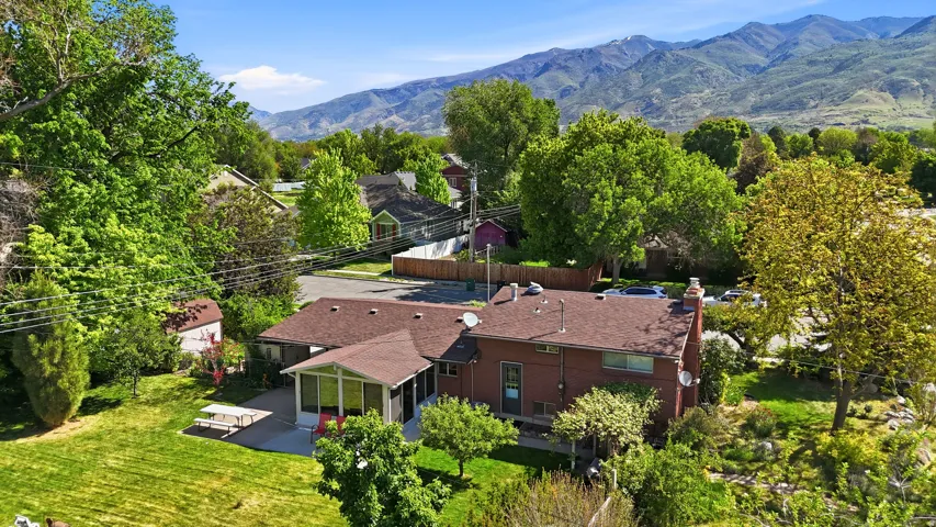 Expansive property featuring a brown roof, red brick exterior, and a screened-in porch