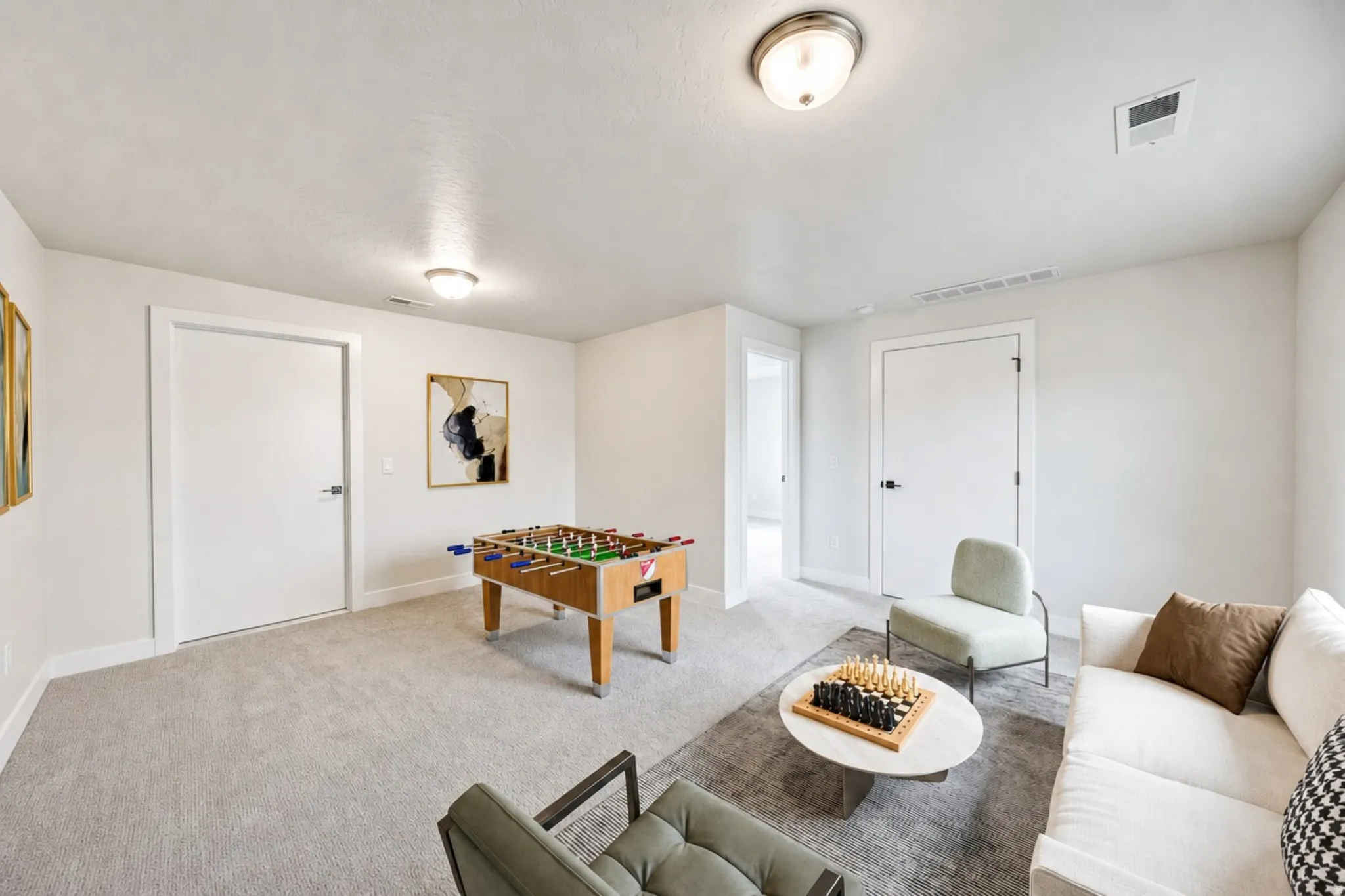 Spacious room featuring light gray carpeting, neutral wall finishes, and recessed lighting