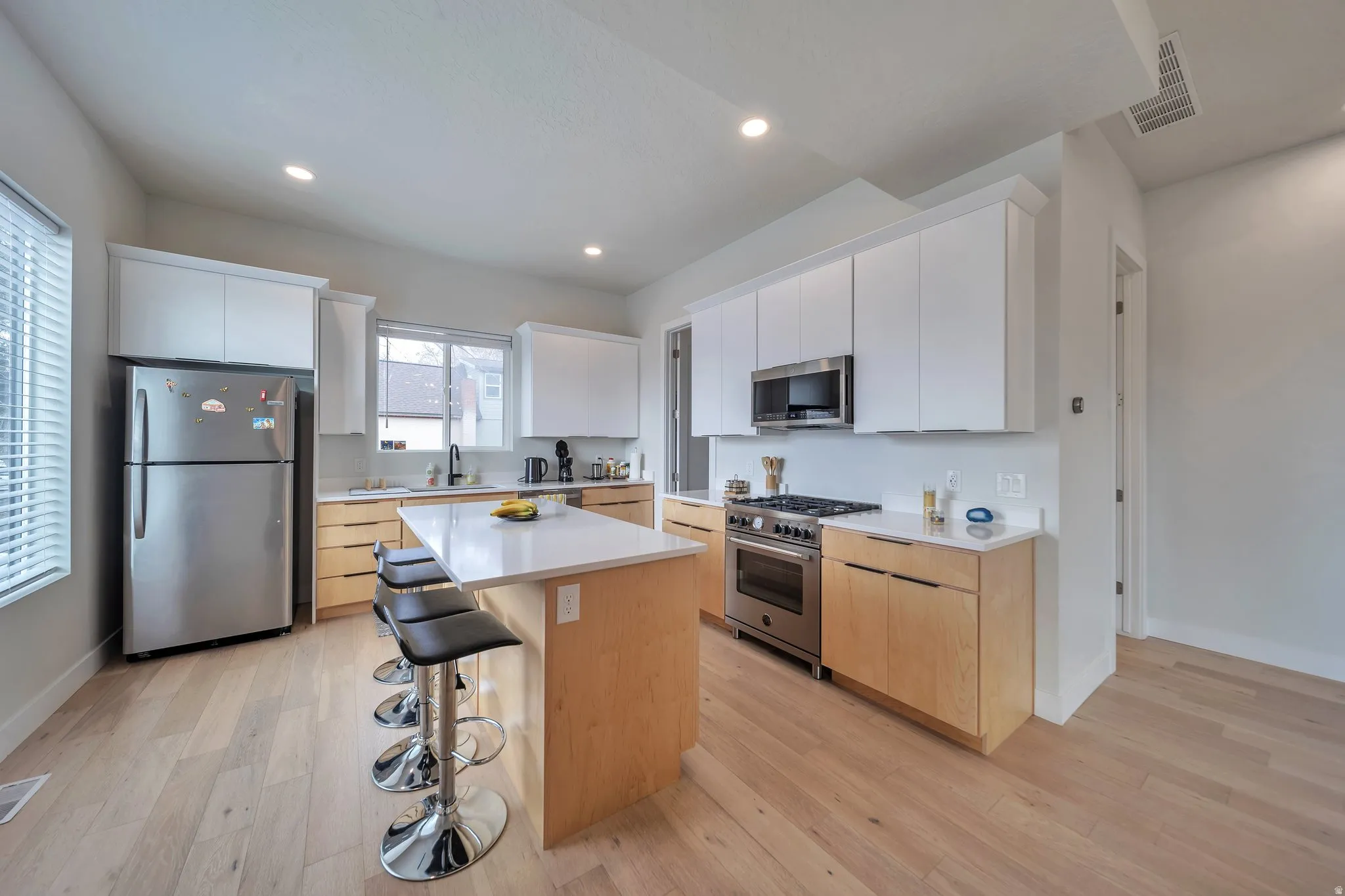 Modern kitchen featuring light wood-finish flooring and a central island