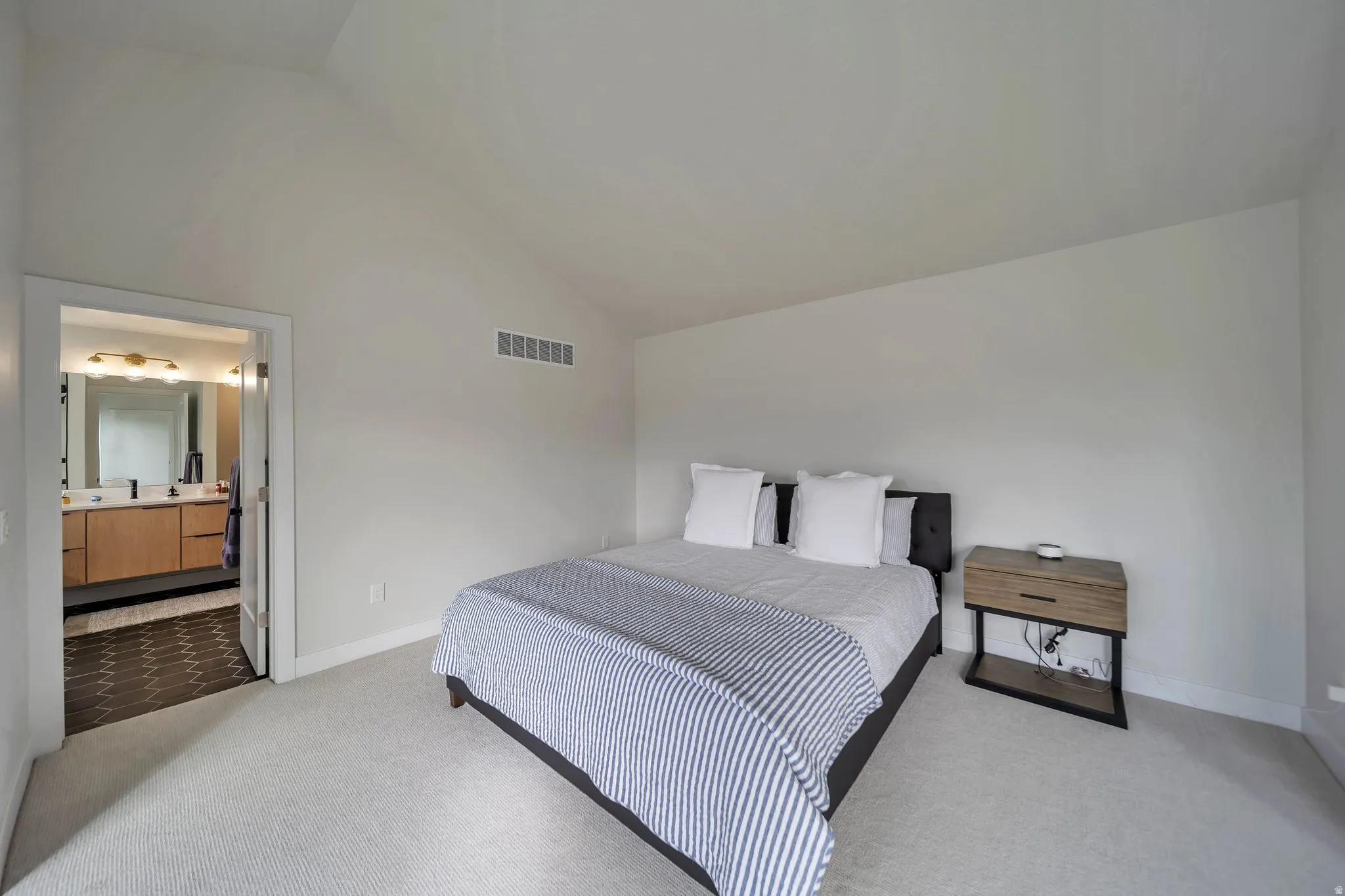 Room featuring a vaulted ceiling and light-toned carpeting