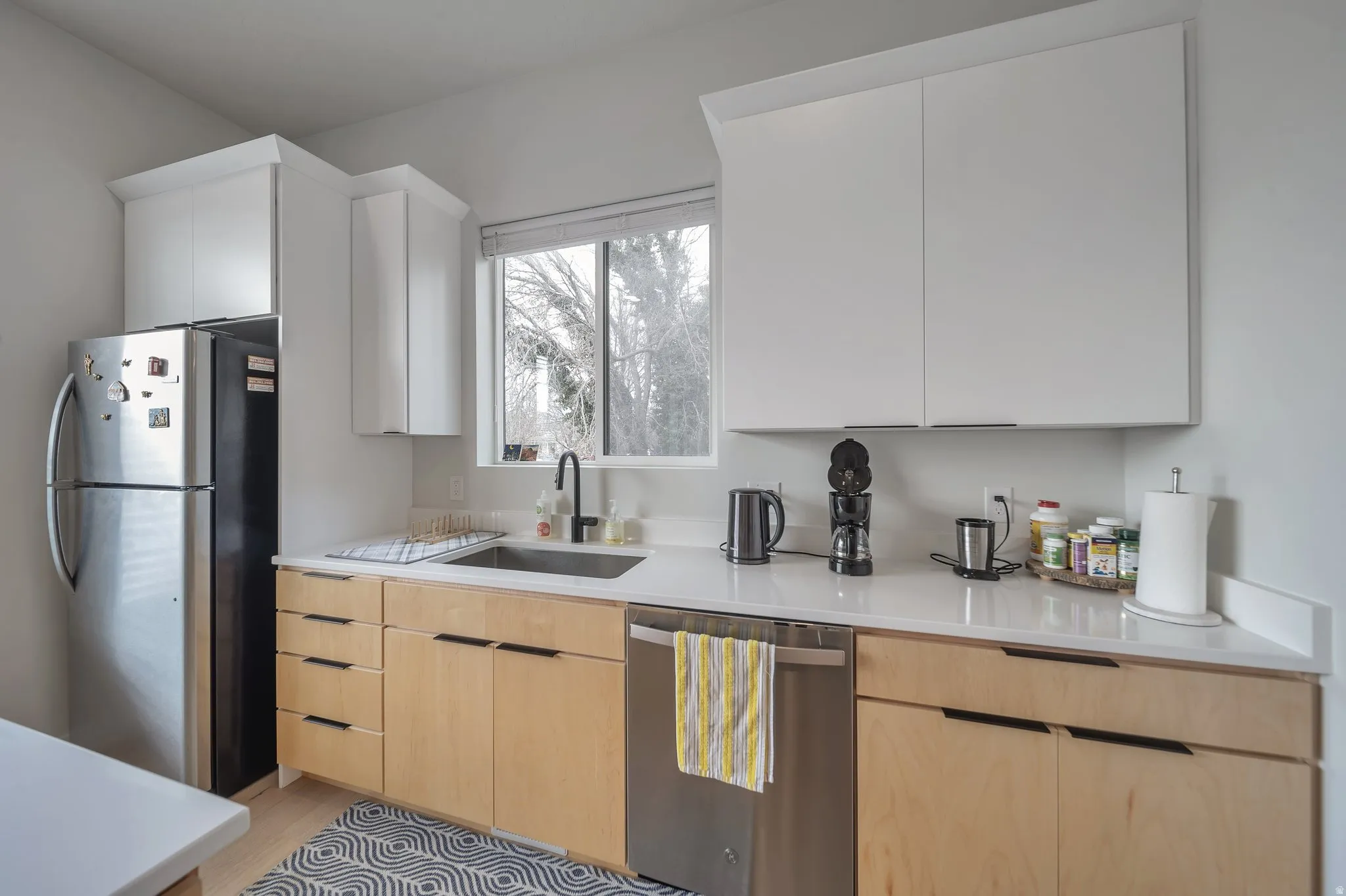 Kitchen featuring two-tone cabinetry with light wood-finish base cabinets and white upper cabinets