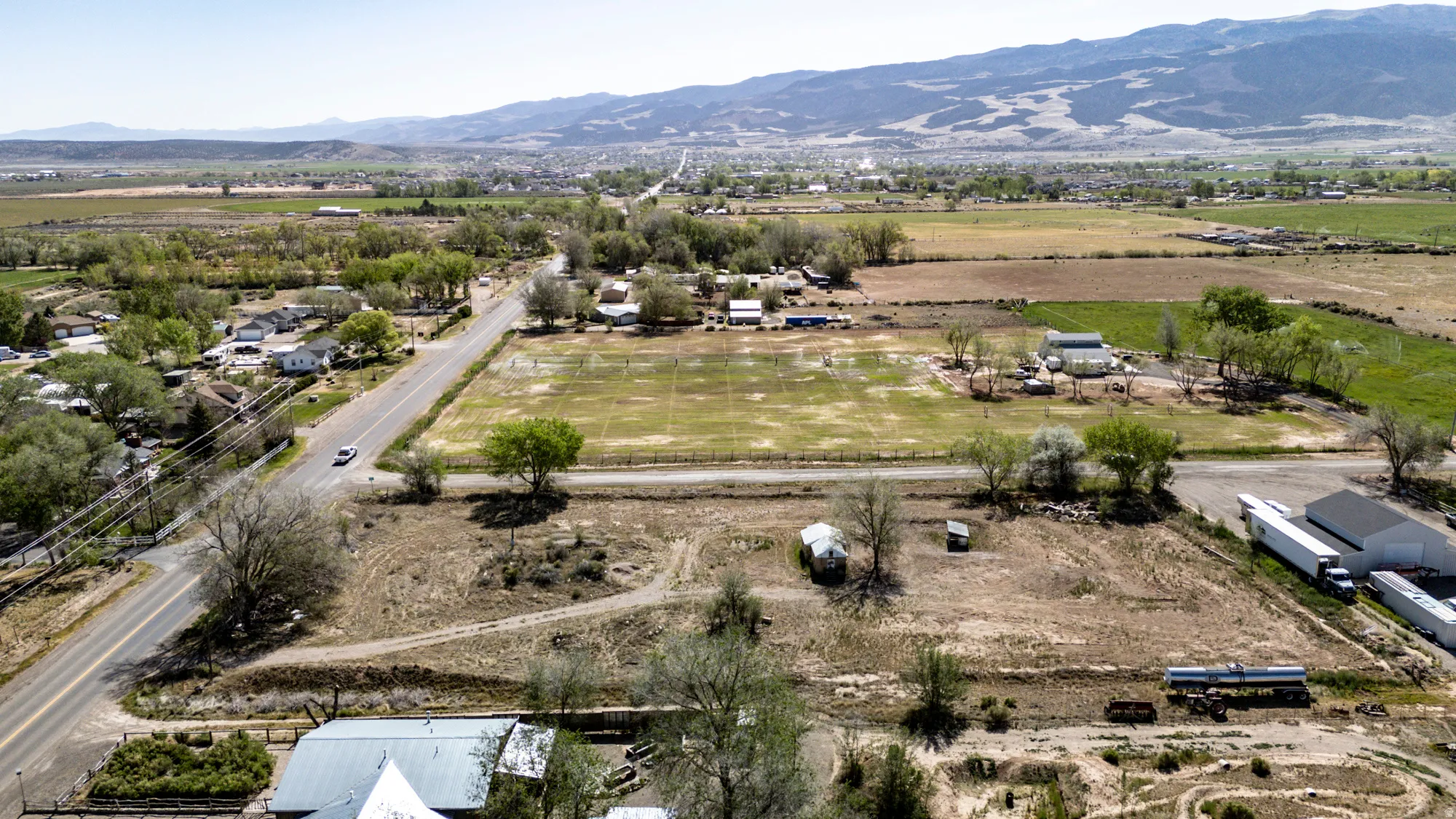 Expansive rural landscape featuring a network of roads, varied terrain, and distant mountainous topography