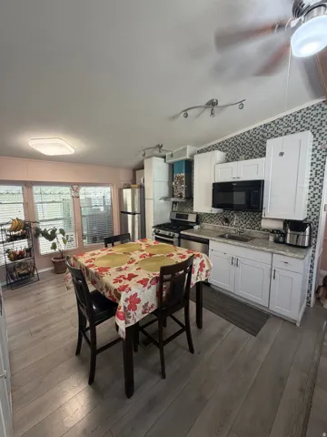 Kitchen featuring light wood-finish flooring and white cabinetry
