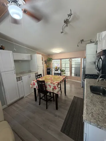 Integrated kitchen and dining area featuring light wood-finish flooring