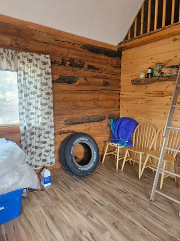 Rustic interior featuring natural log walls and wood-finish flooring