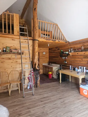 Wood-finish flooring throughout, complemented by log walls and exposed log structural elements