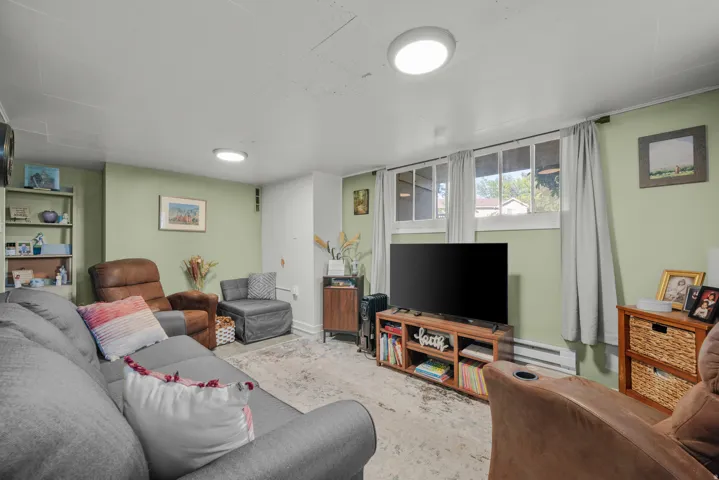 Spacious living area featuring light green walls and light-colored flooring