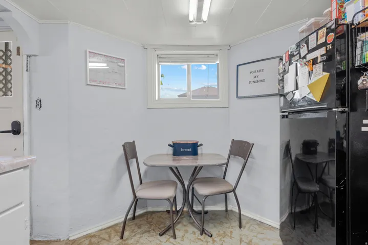 Compact dining area featuring a double-hung window, a built-in fluorescent light fixture, and light-colored walls