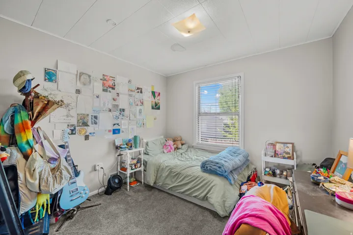 Light gray painted walls, a single window with white blinds, and a built-in overhead light fixture