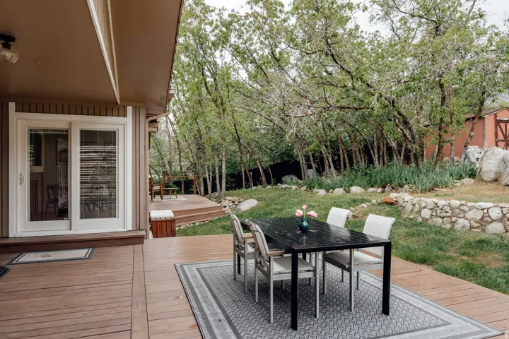 Expansive outdoor living area featuring a multi-level wood-finish deck and sliding glass patio doors