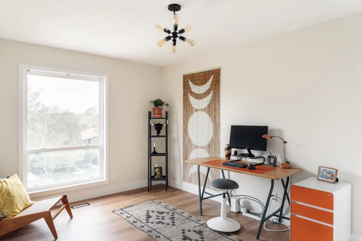 Bright room featuring a large window, wood-finish flooring, a contemporary ceiling light fixture, neutral wall color, and white baseboards