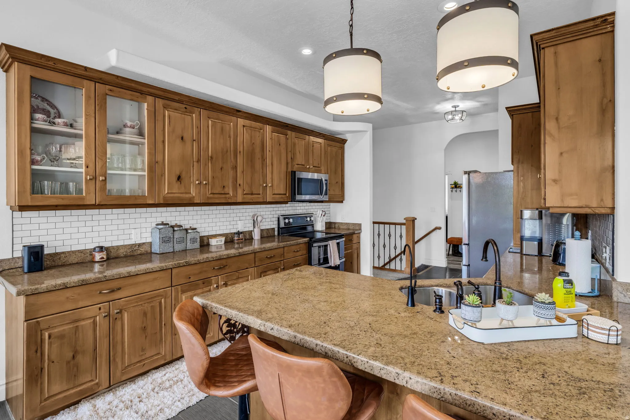 Kitchen featuring wood cabinetry, granite countertops, and a white subway tile backsplash