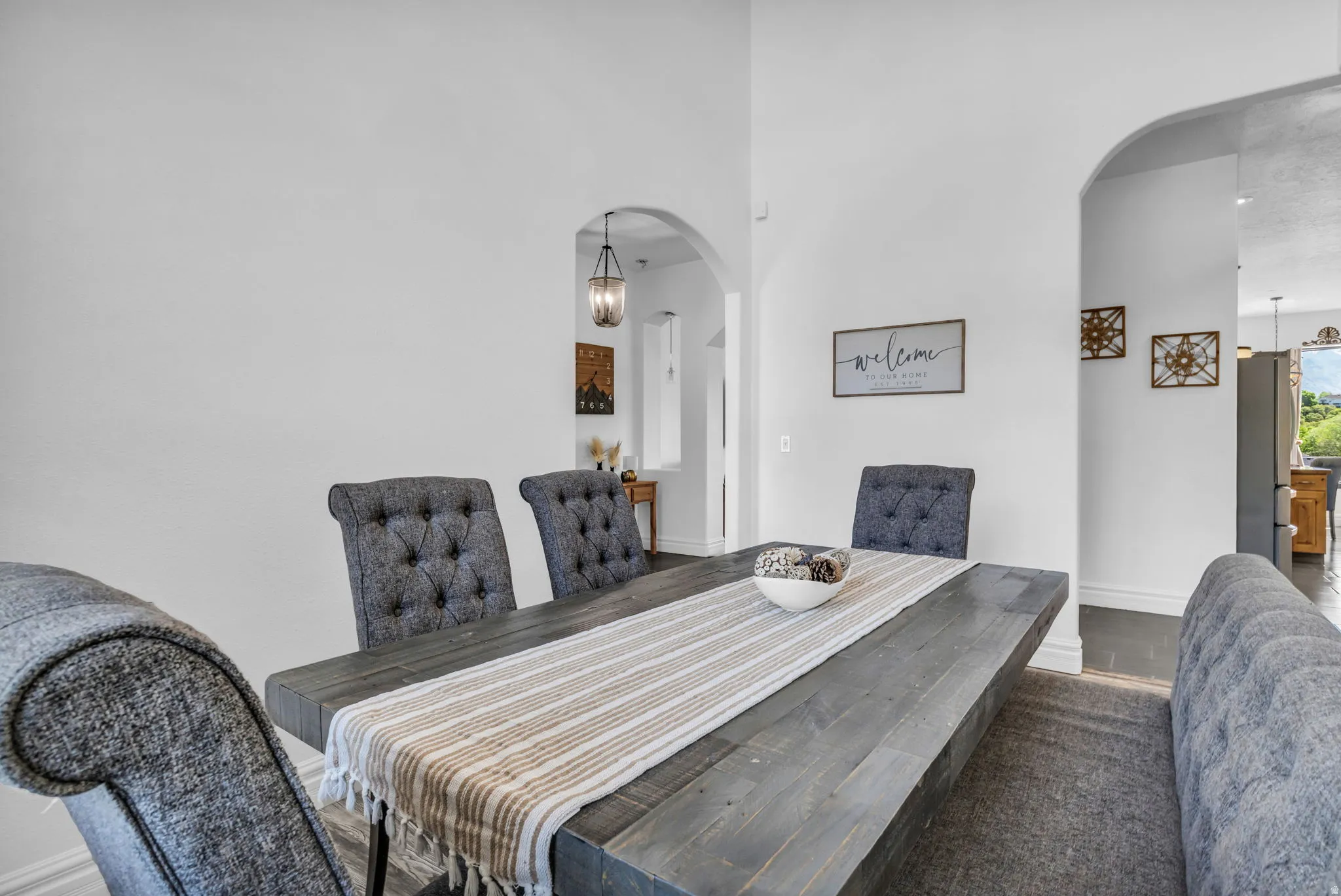 Dining area featuring a dark wood-finish table and arched doorways