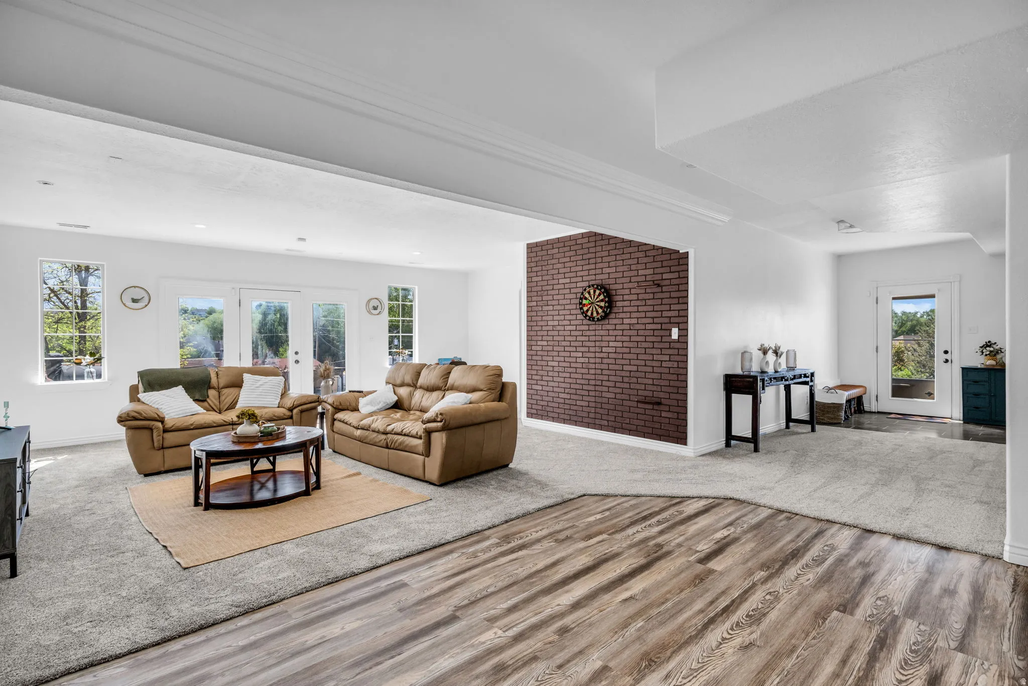 Spacious interior featuring a blend of wood-finish flooring and grey carpeting