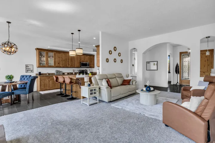 Open-concept living area featuring a kitchen with wood cabinetry, a breakfast bar, and pendant lighting