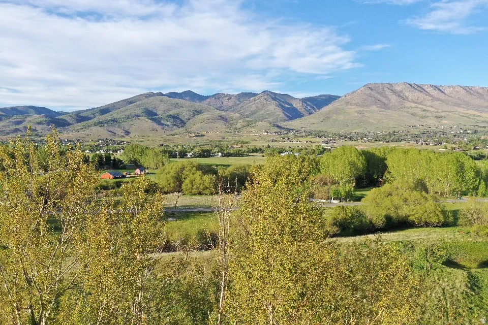Expansive mountain range backdrop with distant residential structures