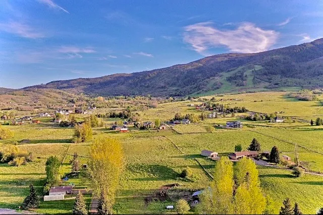 Expansive green landscape featuring rolling hills and distant mountains