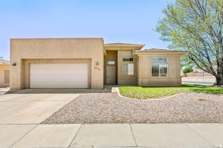 Stucco exterior featuring an attached garage and a covered entryway